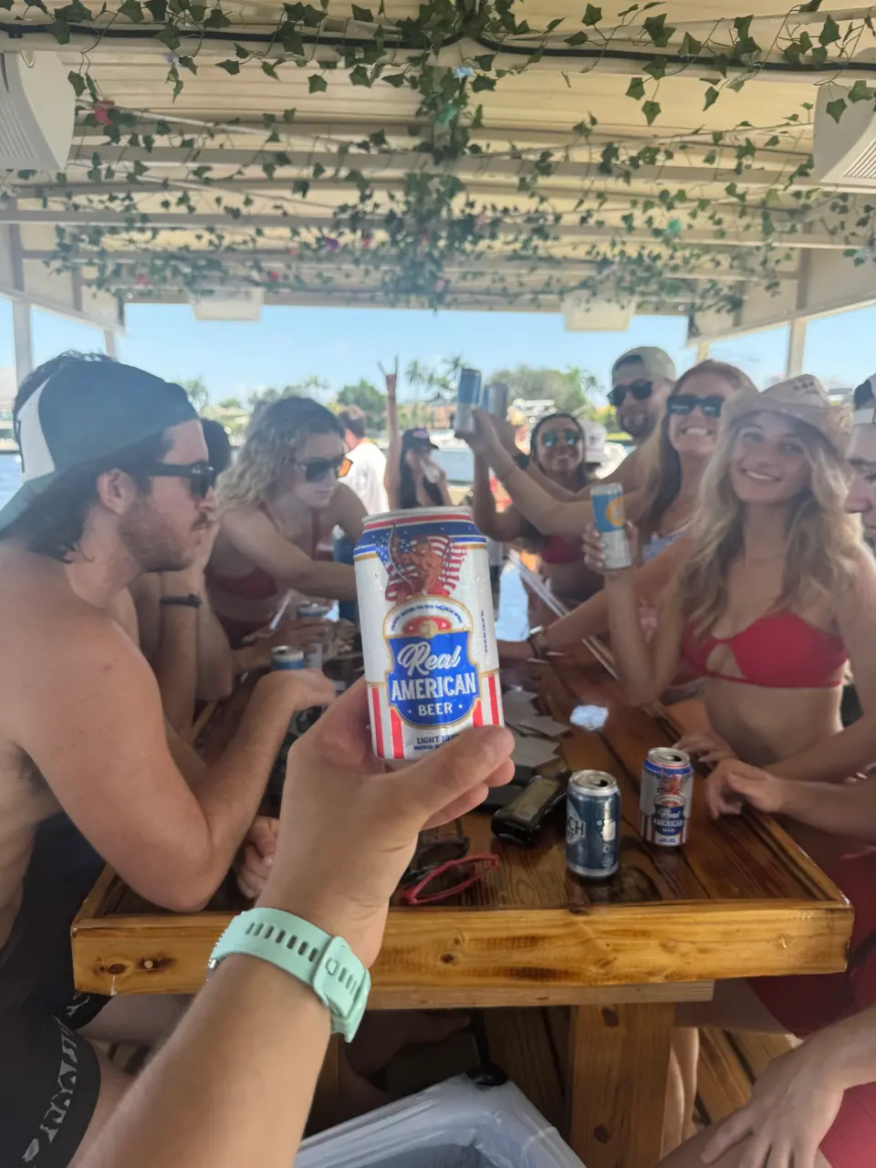 Adult group socializing around the teak table during a private Freaky Tiki charter